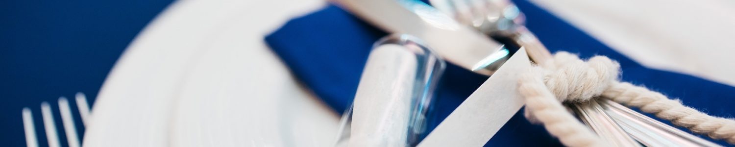 Bottle with a letter lies on the blue serviette on dinner table