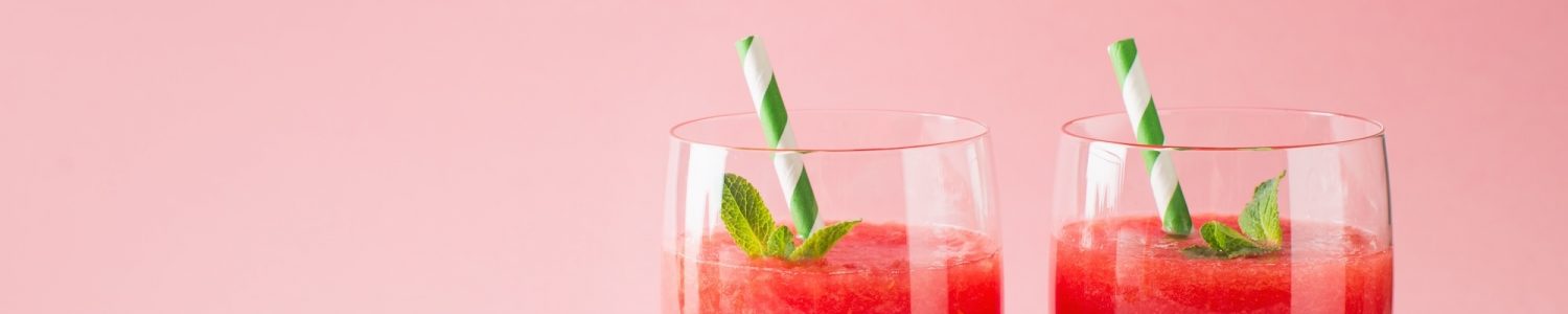Watermelon smoothie with slice of fruit and leaf of mint over pink background